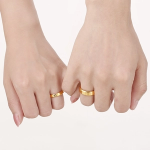 Minimalist gold stainless steel couple rings shown on hands with plain polished finish