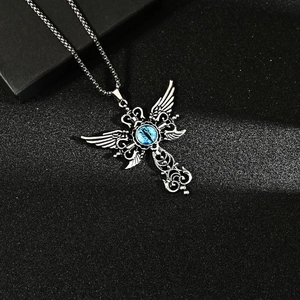 Silver devil eye wing cross necklace with blue stone on black textured background