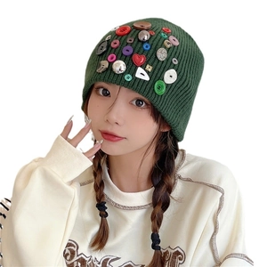 Dark green knitted beanie for women featuring colorful button accents and slouchy style