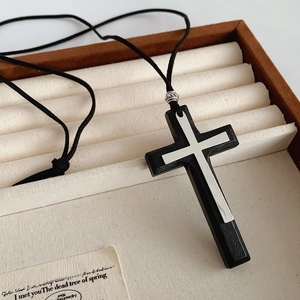 Detail of wooden and metal cross pendant resting in a vintage Paris jewelry box