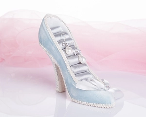 Detailed view of light blue high-heel jewelry holder with lace trim and pearl earrings