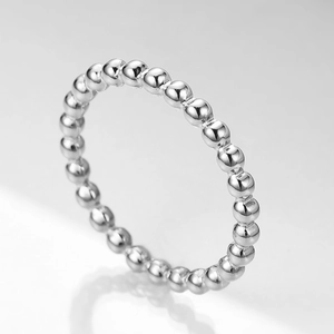 Detailed close-up of a silver stainless steel minimalist beaded ring with a glossy finish