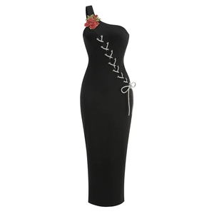 Détail de robe noire à une épaule avec fleur 3D rouge et laçage croisé argenté sur le côté