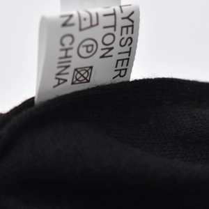 Detail of product care label showing polyester cotton blend material and washing symbols