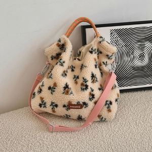 Close-up of fluffy lamb wool tote bag with pixelated floral patterns and woven handles