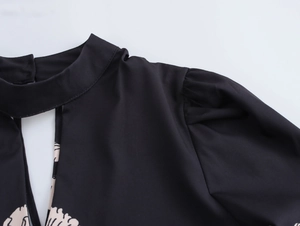 Detail of vintage black blouse featuring a mandarin collar, hollow-out lace and lantern sleeves