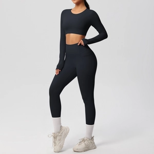 Detail of black seamless yoga set showing high-waist leggings and cropped long sleeve top