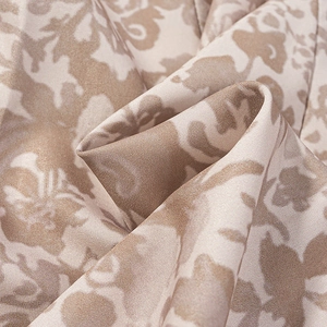 Vue macro du tissu damassé beige et havane scintillant avec motif floral élégant