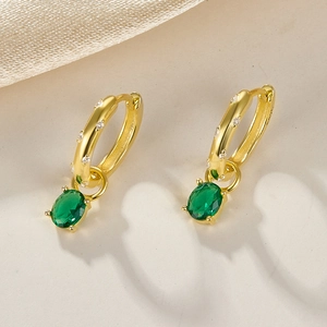Close-up of S925 sterling silver gold earrings with green oval zircon pendants and diamonds
