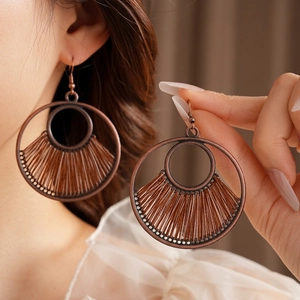 Vintage bronze double hoop earrings with ethnic fan-shaped patterns shown on model