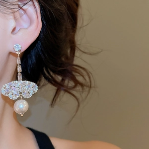 Detailed view of butterfly pearl tassel earrings featuring diamonds and gold finish