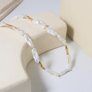 Baroque natural freshwater pearl necklace with gold metal accents on geometric props