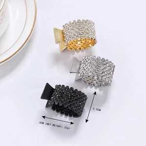 Detailed size view of round alloy ponytail hair clips with crystals in gold, silver, and black
