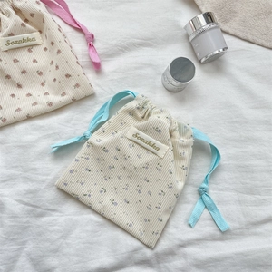 Detailed macro view of floral corduroy drawstring pouch for lipstick and small cosmetics