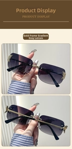 Detail view of gold metal butterfly accent and gradient grey lenses on rimless sunglasses