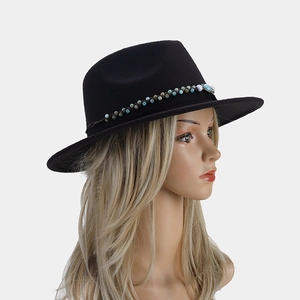 Détail d'un chapeau fedora noir en laine avec une bande perlée colorée de style ethnique