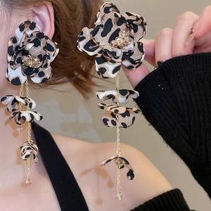 Close-up of leopard print fabric flower earrings with long gold chain tassels and beads