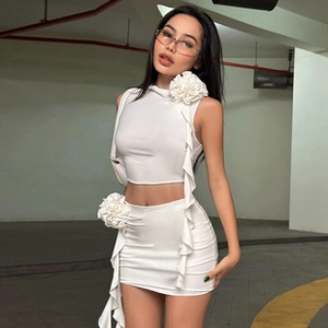 Close-up of white two-piece set featuring 3D floral ruffles on top and mini skirt