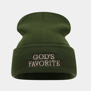 Détail du bonnet en maille vert foncé avec broderie rose 'GOD'S FAVORITE' devant