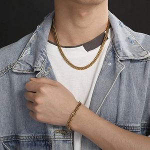 Men's golden cuban link necklace and bracelet set styled with denim jacket
