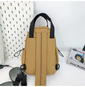 Detail view of khaki nylon lightweight chest bag with black straps and buckle details