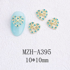 Détail macro de breloques cœur pour ongles avec strass bleus et nœud sur ongle bleu