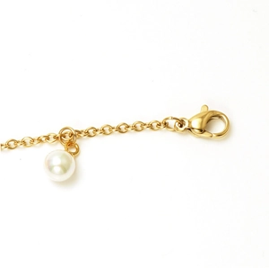 Close-up of 18K gold stainless steel chain with lobster clasp and white pearl charm