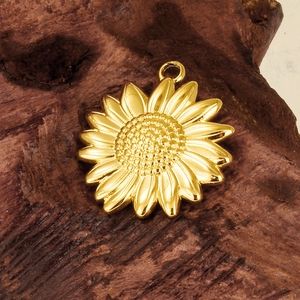 304 stainless steel golden sun pendant charm with detailed petals on dark wood background