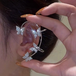 Elegant silver ear cuff with sparkling crystal butterflies on the earlobe
