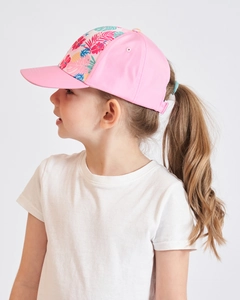 Close-up of pink children's ponytail baseball cap with tropical flower and leaf patterns