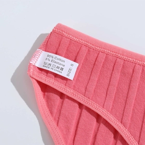 Detailed macro view of the care label on pink cotton ribbed panties showing S size