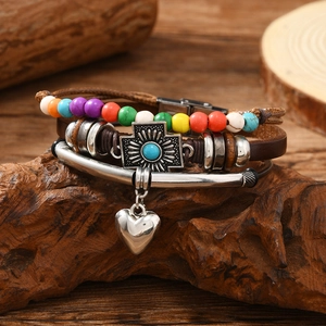 Macro detail of multi-layer leather bracelet with colorful beads and cross on wood