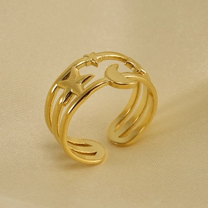 Eleganter 18K vergoldeter Ring mit Stern-Mond-Ausschnitt auf luxuriöser Champagner-Seide