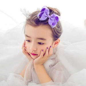 Girl wearing a 4-inch purple handmade grosgrain ribbon bow hair clip accessory
