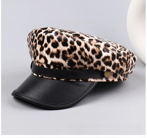 Detail of leopard print flat top hat featuring black faux leather brim and gold button