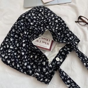 Close-up of heart pattern canvas tote with secure magnetic clasp and inner books