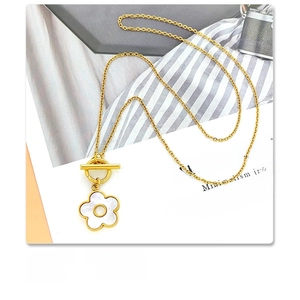 Detail of 18K gold plated titanium steel necklace with white shell flower and OT clasp