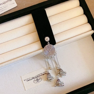Close-up of ethnic silver bell tassel earrings inside a premium black velvet jewelry box