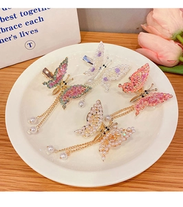 Detail of butterfly hair clips with pearl tassels and rhinestones in a gift display