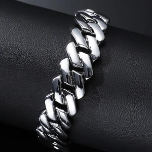 Polished silver Cuban link bracelet for men in hip hop style on dark leather background