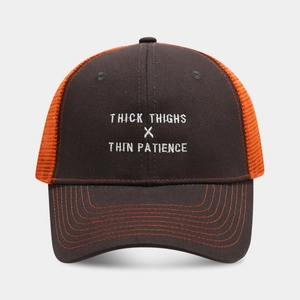 Close-up of embroidered text on black and orange mesh trucker hat with contrast stitching