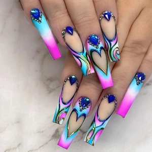 Close-up of blue and pink gradient press-on nails with heart patterns and rhinestones