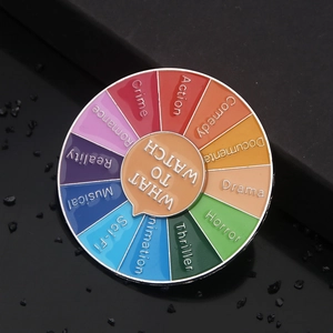 Macro shot of circular rotating enamel pin featuring movie genres and film-themed design