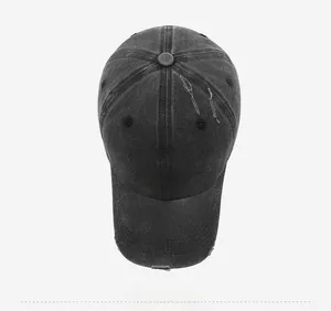 Close-up of distressed washed cotton baseball cap with white FRAGRANCE letter embroidery