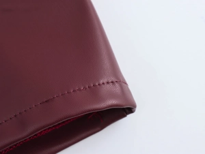 Detailed close-up showing precision stitching on dark red PU leather fabric texture