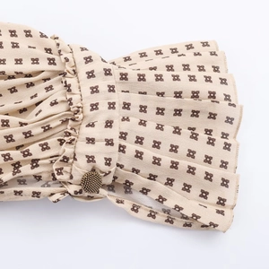 Detail of smocked flared cuffs with geometric print and vintage metal button accent