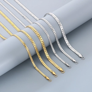 Detailed comparison of gold and silver flat snake chains on a minimalist display stand