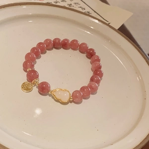 Pink strawberry crystal beaded bracelet with a gold charm and white heart accent