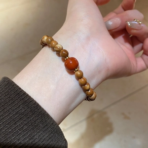 Macro shot of a Chinese vintage beaded bracelet with brown Tiger Eye stones on wrist