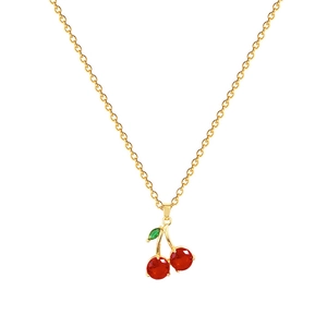 Élégant collier en acier titane doré avec pendentif cerise en cristal rouge sur fond blanc